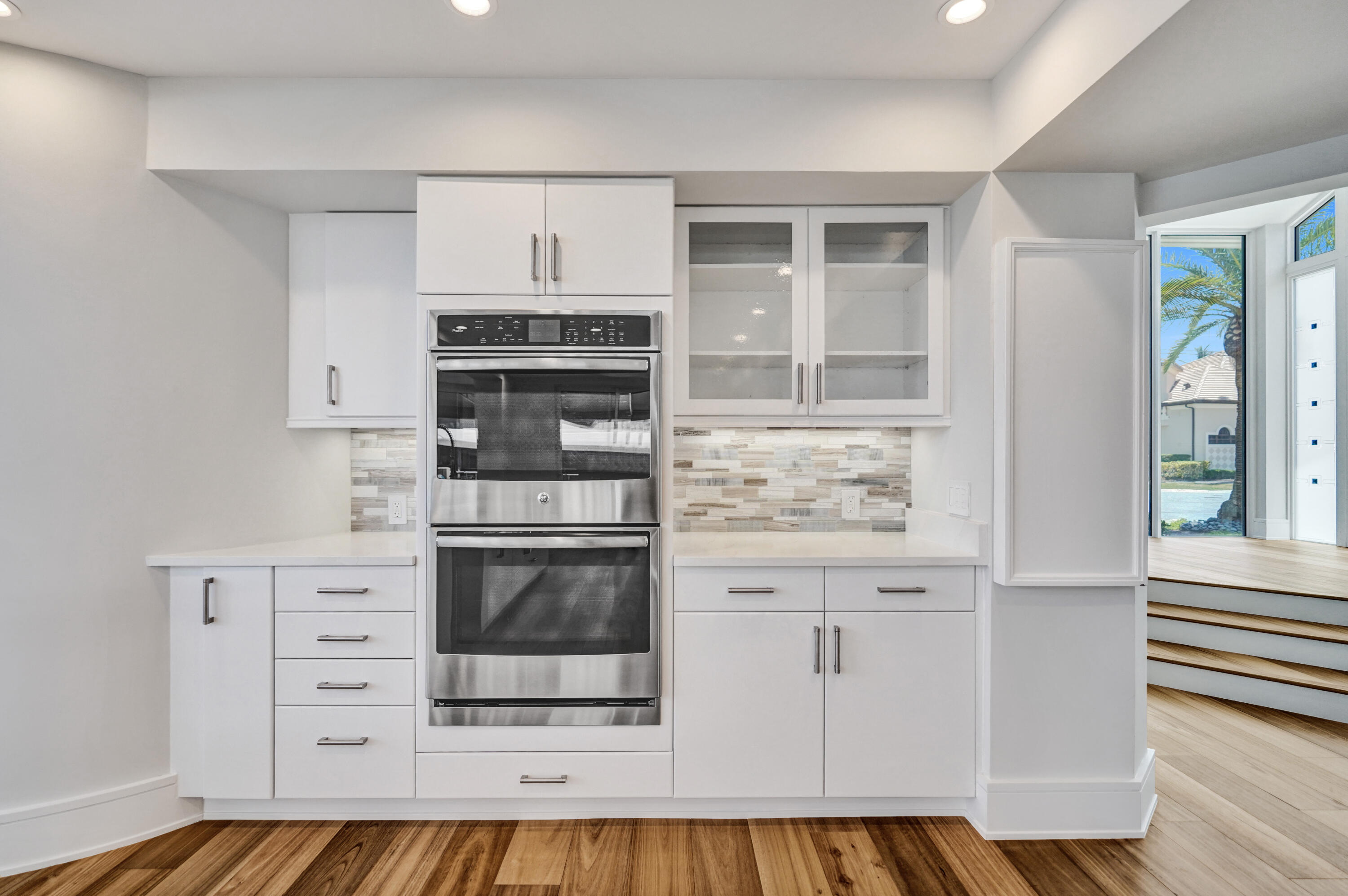 961 Iris Drive Delray Beach, FL 33483 - Photo 25 of 59 a kitchen with stainless steel appliances granite countertop a stove and white cabinets