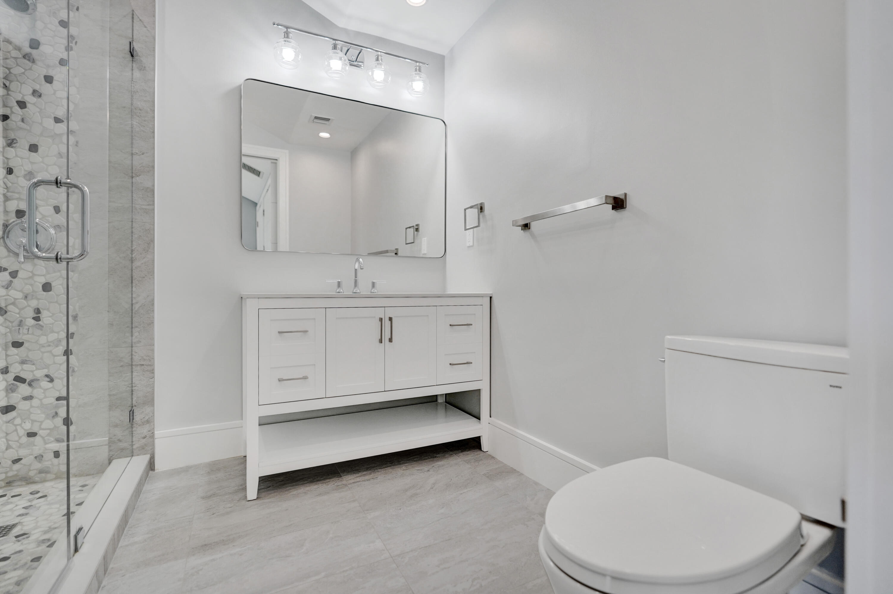 961 Iris Drive Delray Beach, FL 33483 - Photo 36 of 59 a bathroom with a toilet a sink a mirror and vanity