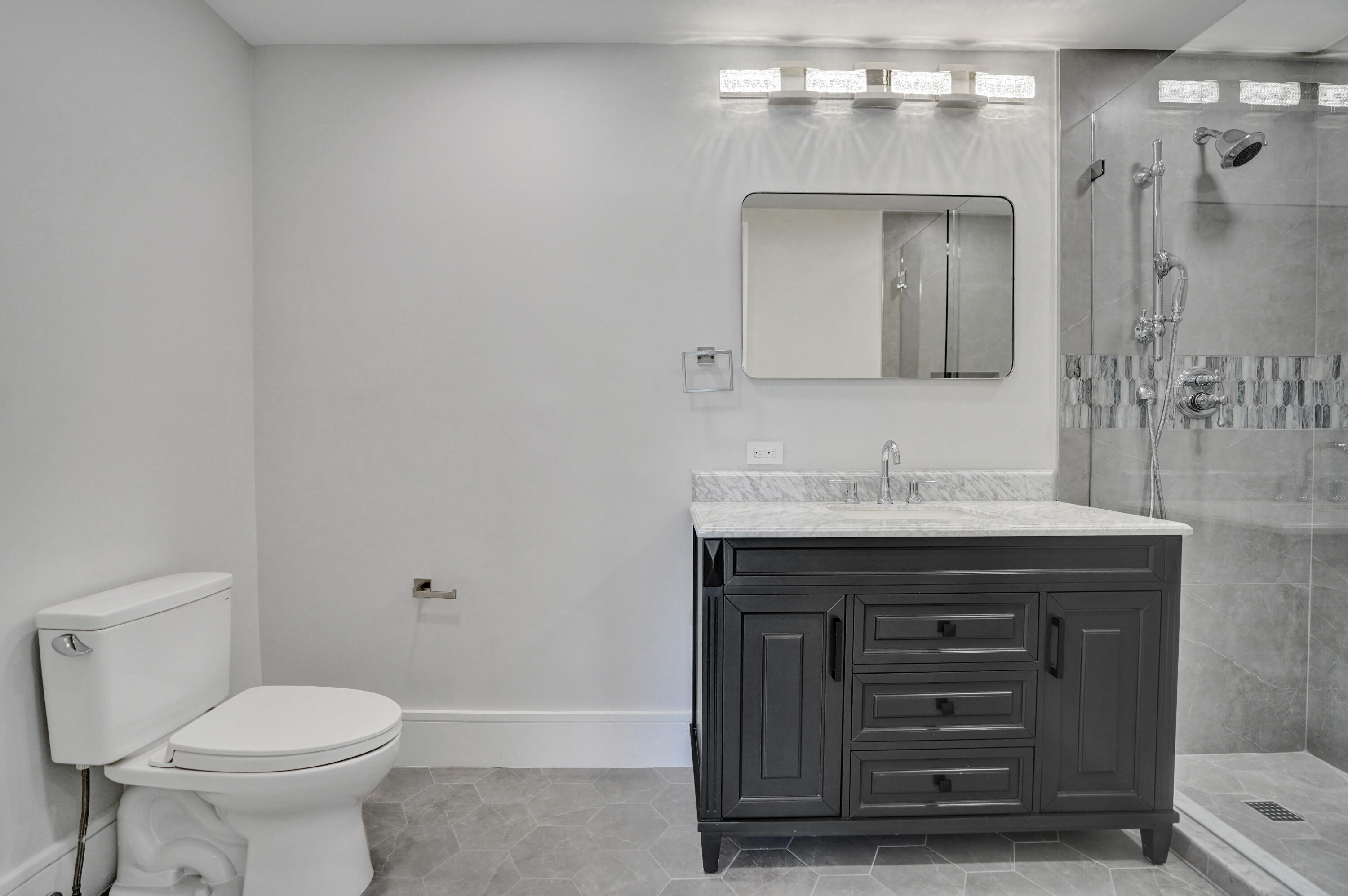961 Iris Drive Delray Beach, FL 33483 - Photo 38 of 59 a bathroom with a sink a toilet and a mirror