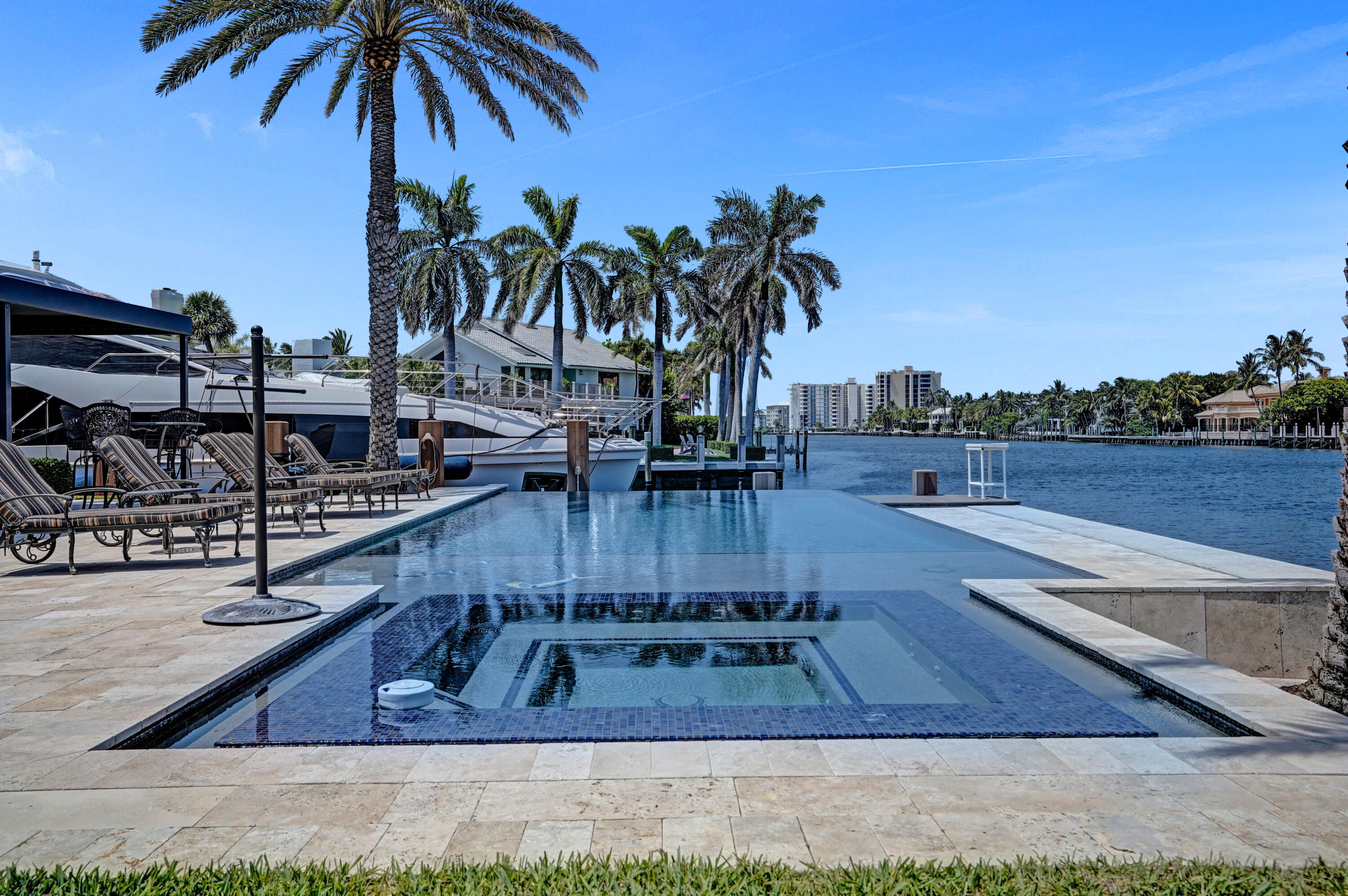 961 Iris Drive Delray Beach, FL 33483 - Photo 43 of 59 a view of a swimming pool with a table and chairs