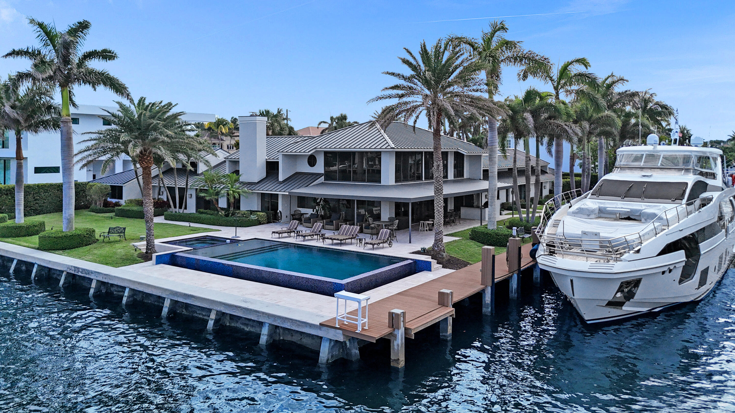 961 Iris Drive Delray Beach, FL 33483 - Photo 55 of 59 a view of a patio with table and chairs potted plants and palm tree