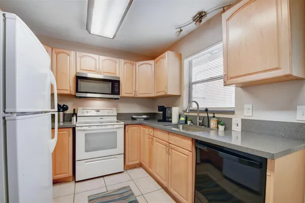 a kitchen with stainless steel appliances a sink cabinets and a window