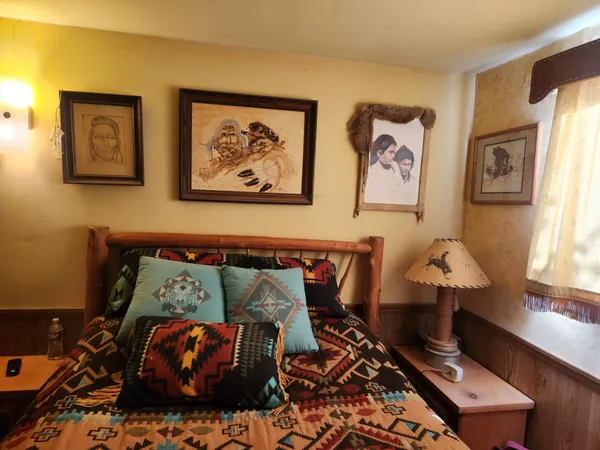 a bedroom with a bed and a painting on the wall