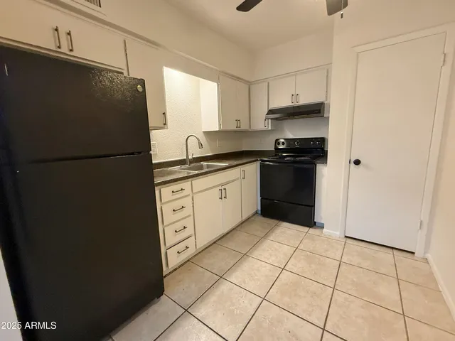 a kitchen with stainless steel appliances a refrigerator sink and cabinets