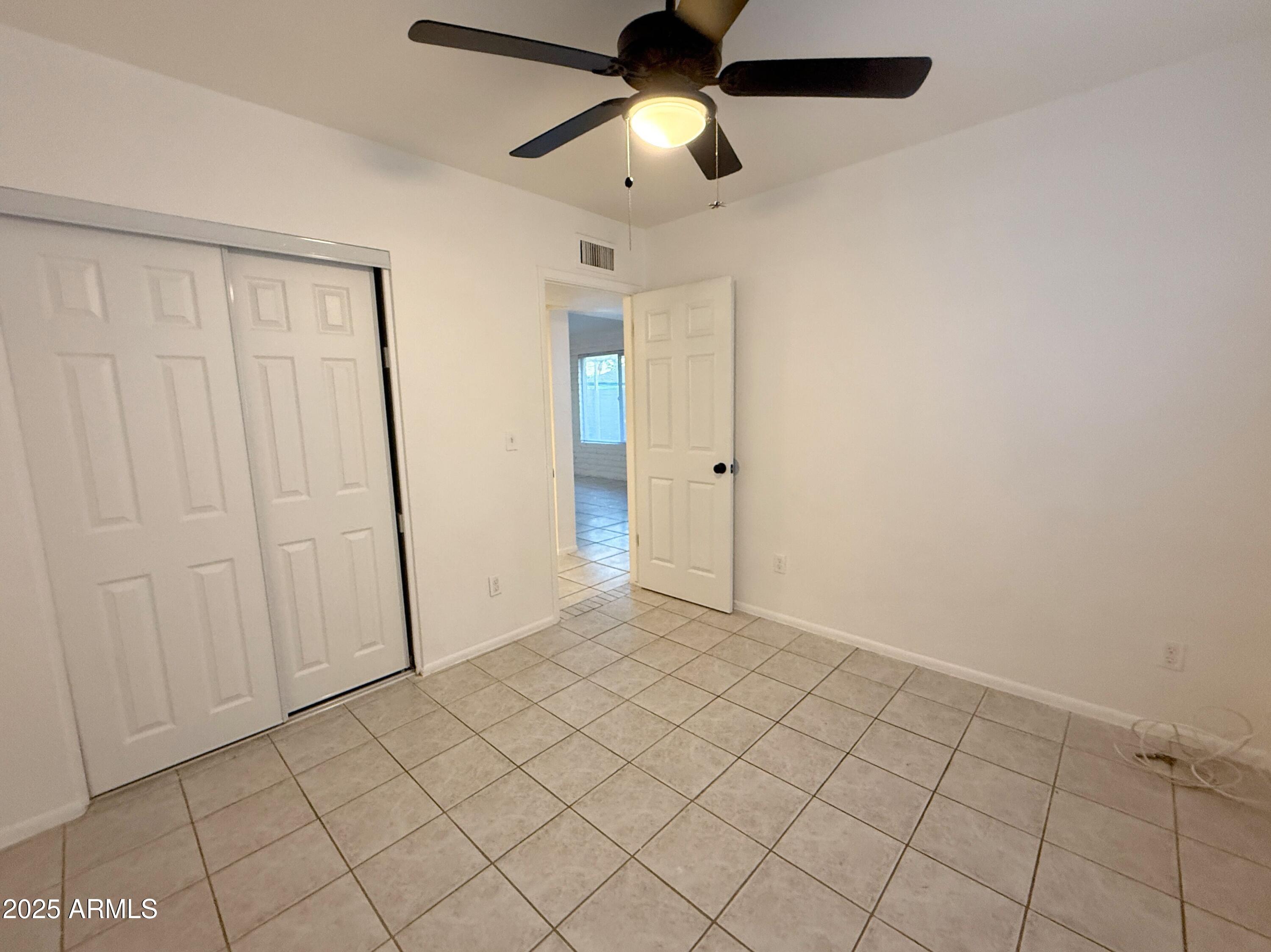 3125 North 66th Street, Unit 2 Scottsdale, AZ 85251 - Photo 6 of 10 an empty room with closet and a chandelier fan