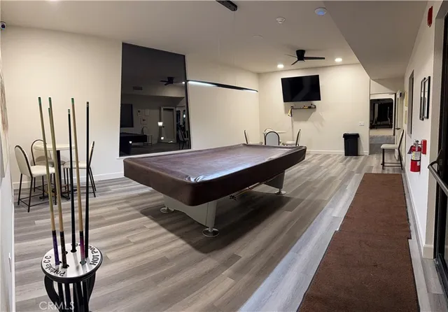 a living room with stainless steel appliances furniture a fireplace and a flat screen tv