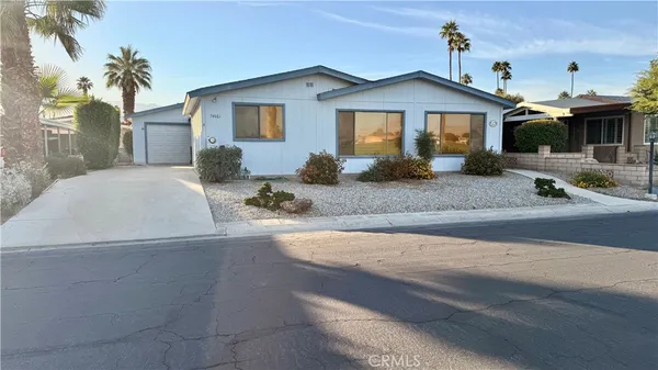 a front view of a house with yard and parking