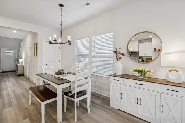 a kitchen with stainless steel appliances a table and chairs in it