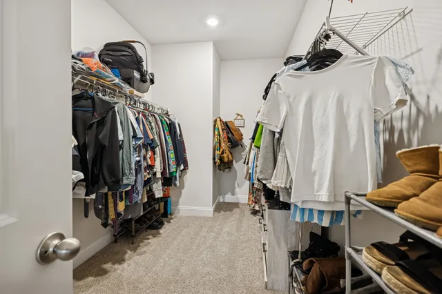 a view of walk in closet with clothes and shoes