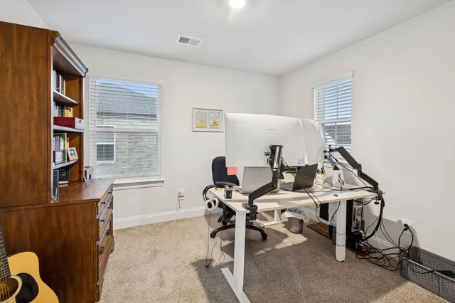 a view of a workspace with furniture and a window