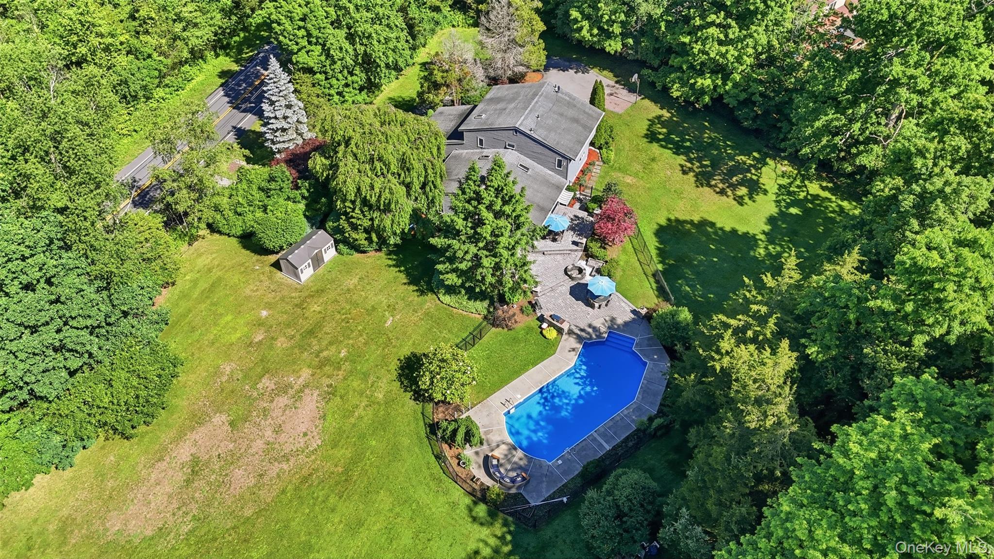 985 Craigville Road Chester, NY 10918 - Photo 1 of 36 Expansive property featuring a large in-ground pool, extensive paved patio, substantial green space, mature trees, and a detached storage shed