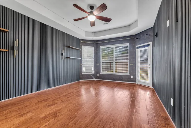 a view of a livingroom with a ceiling fan and wooden floor