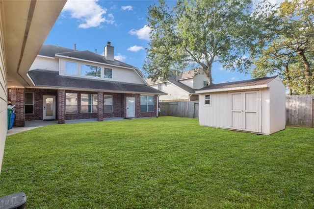 a view of a yard in front of a house with large tree