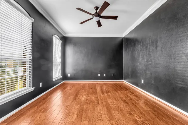 a view of empty room with a window and a ceiling fan