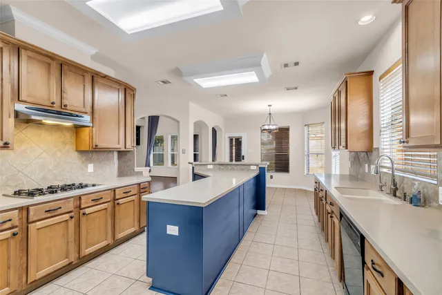 a large kitchen with stainless steel appliances granite countertop a sink and cabinets