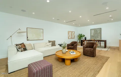 a living room with furniture a table and a potted plant
