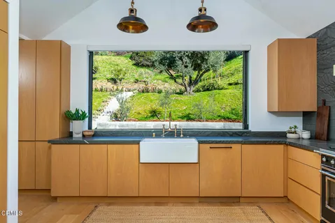 a kitchen with stainless steel appliances wooden cabinets and a large window