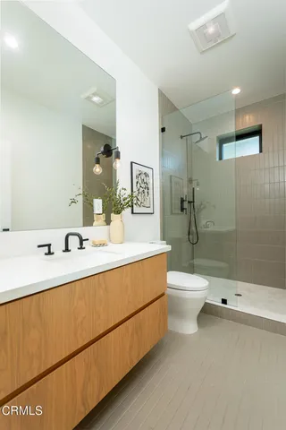 a bathroom with a double vanity sink toilet and shower