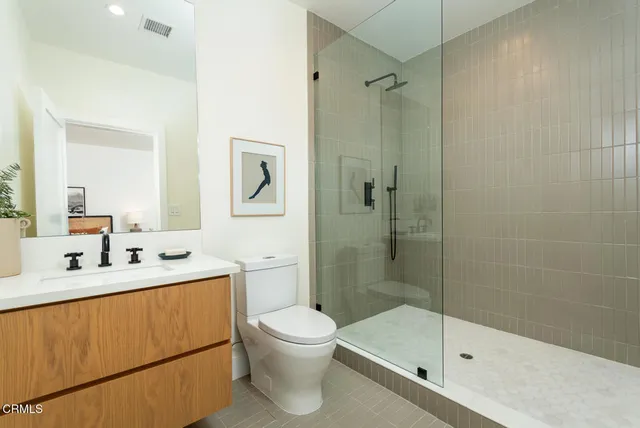 a bathroom with a sink mirror toilet and shower