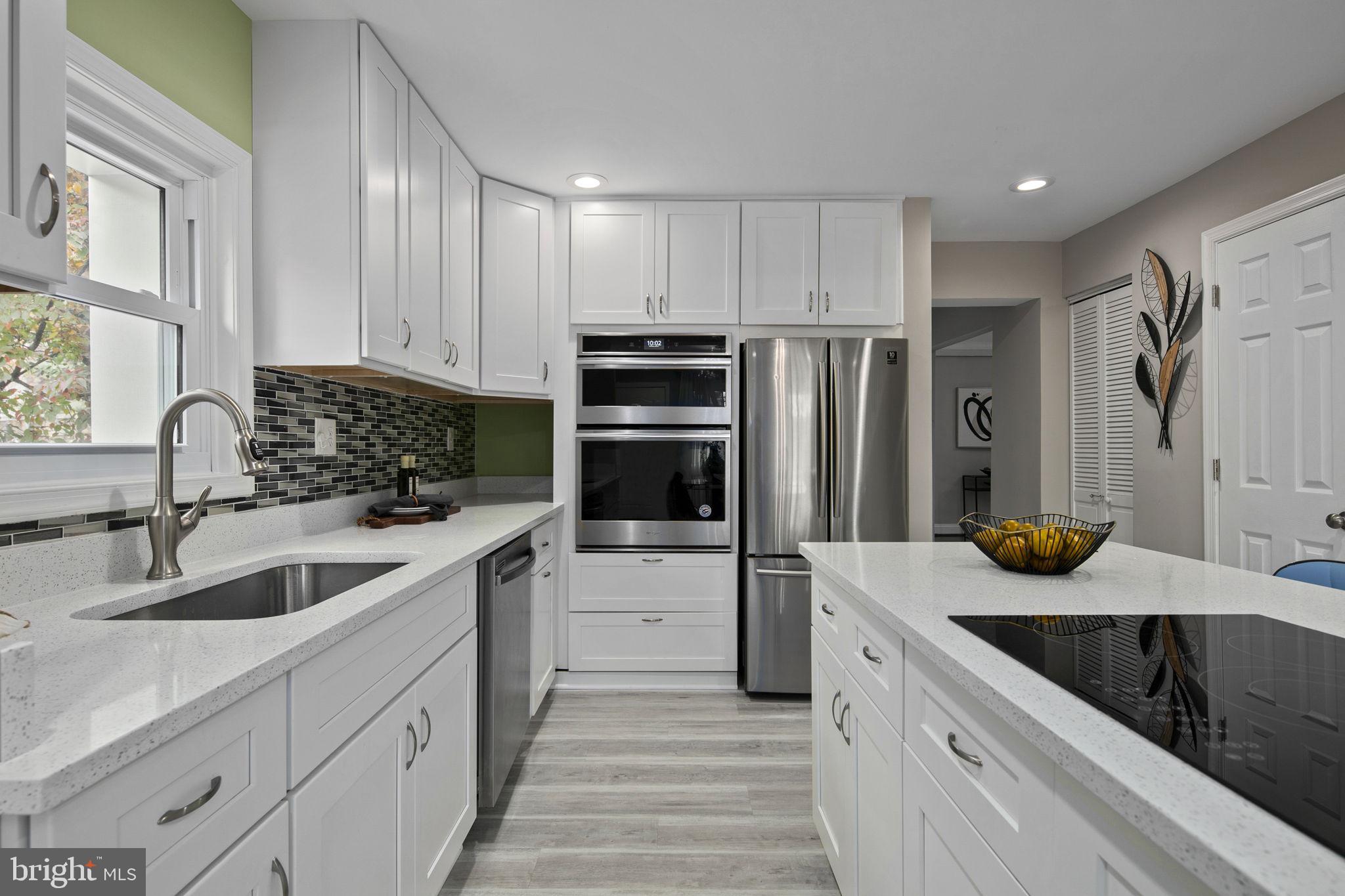 3424 Spring Drive Alexandria, VA 22306 - Photo 16 of 52 a kitchen with white cabinets and stainless steel appliances