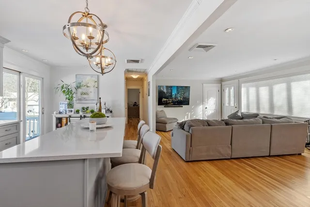 a living room with furniture white walls and kitchen view