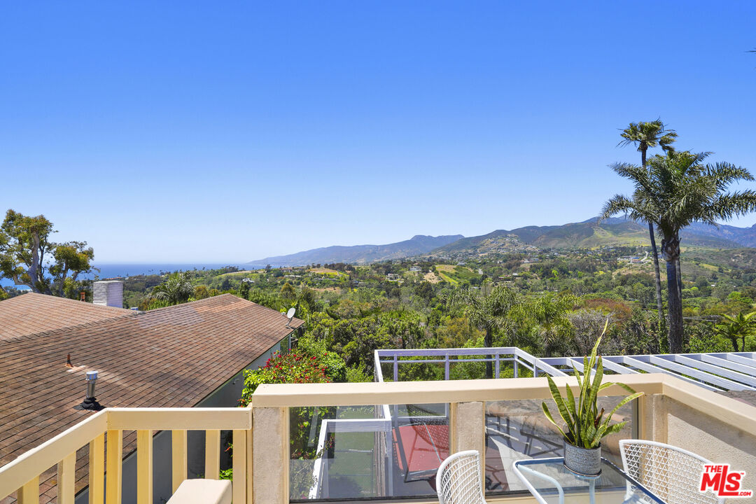 29355 Heathercliff Road, Unit GUESTHOUSE Malibu, CA 90265 - Photo 16 of 26 a view of a balcony with two chairs and a table