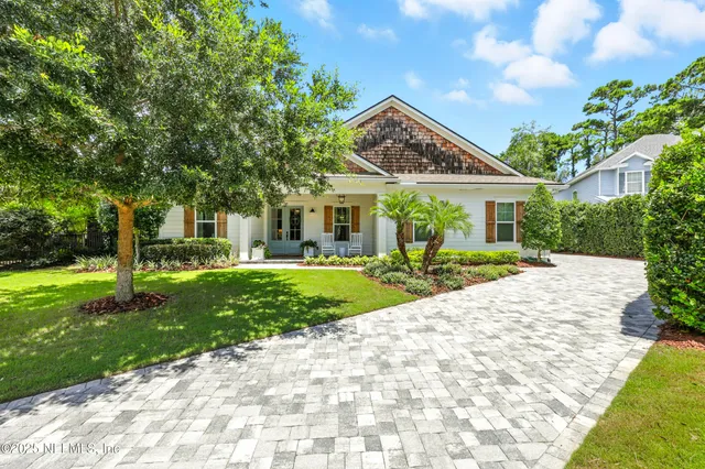a view of a big house with a big yard and large trees