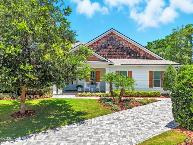 an aerial view of residential houses with outdoor space and parking