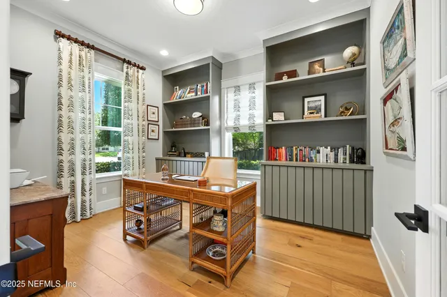 a kitchen with stainless steel appliances kitchen island granite countertop a stove top oven a sink dishwasher and white cabinets with wooden floor