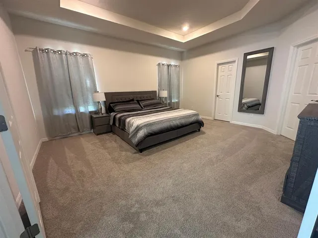 a spacious bedroom with a bed and a window