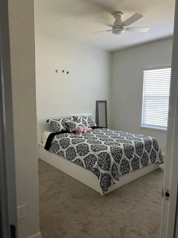 a bed sitting in a bedroom next to a window