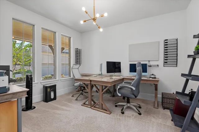 a view of a workspace with furniture and a window