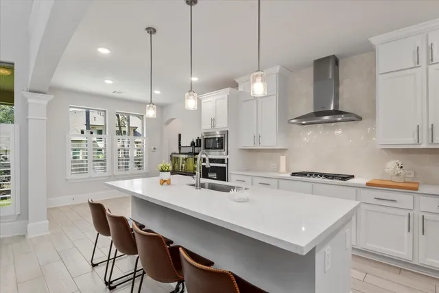 a kitchen with a sink a stove a refrigerator and white cabinets with wooden floor
