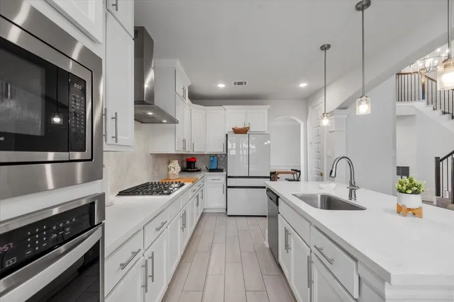 a kitchen with counter top space a sink stainless steel appliances and cabinets