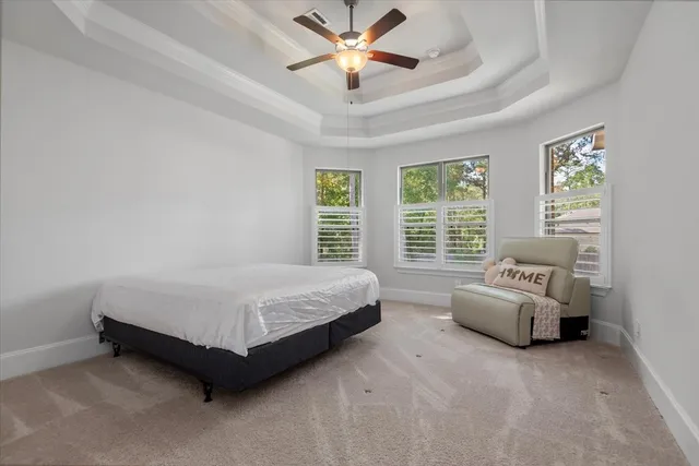 a spacious bedroom with a bed and a chandelier