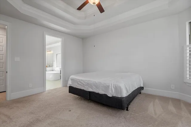 a spacious bedroom with a bed and a ceiling fan