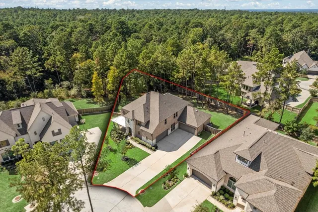 an aerial view of a house with a yard and trees