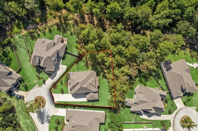 an aerial view of a house with a yard and lake view