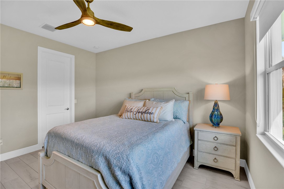 105 Night Hawk Way Sebastian, FL 32958 - Photo 21 of 36 a bedroom with a bed and a chandelier