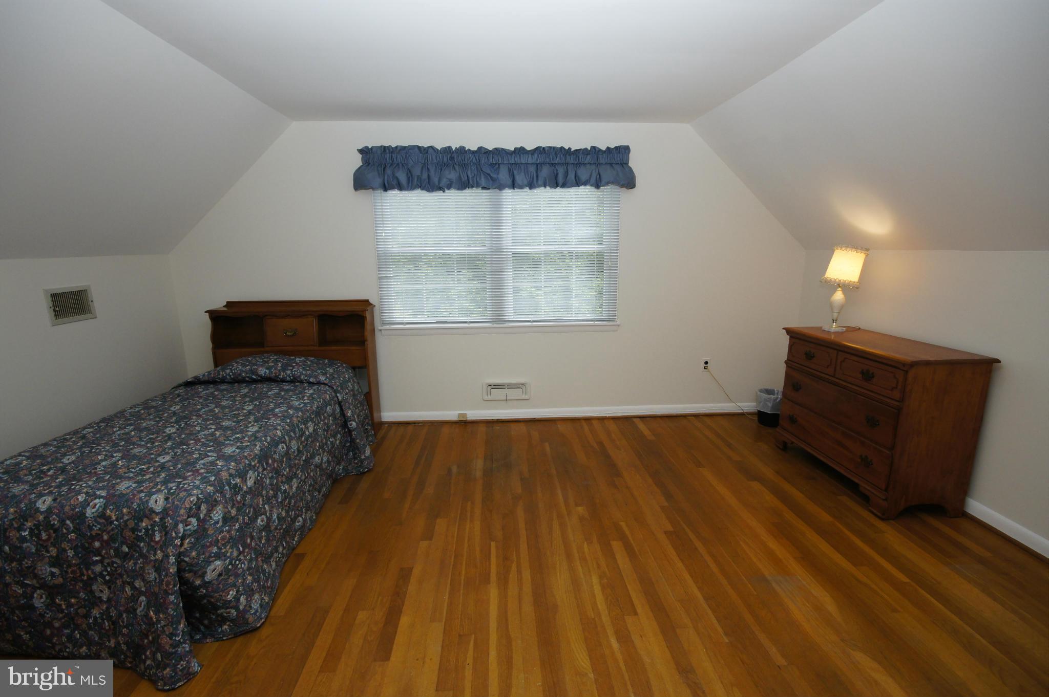 6202 Gilston Park Road Baltimore, MD 21228 - Photo 10 of 21 a bedroom with a bed and wooden floor