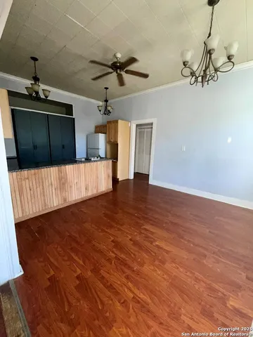 a view of a livingroom with wooden floor and ceiling fan