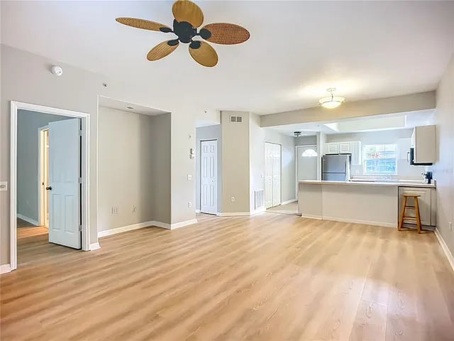 a view of empty room with wooden floor and window