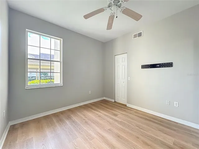 an empty room with windows and fan