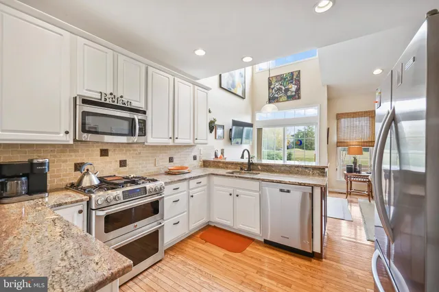 a living room with furniture kitchen view and a chandelier