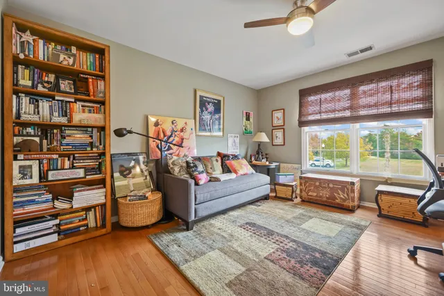 a view of a hallway with wooden floor and furniture