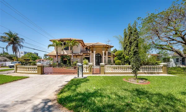 a front view of a house with a garden and trees