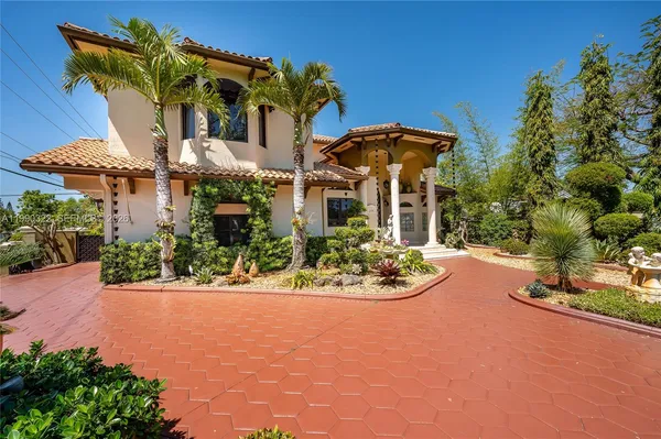 front view of a house with a yard and potted plants