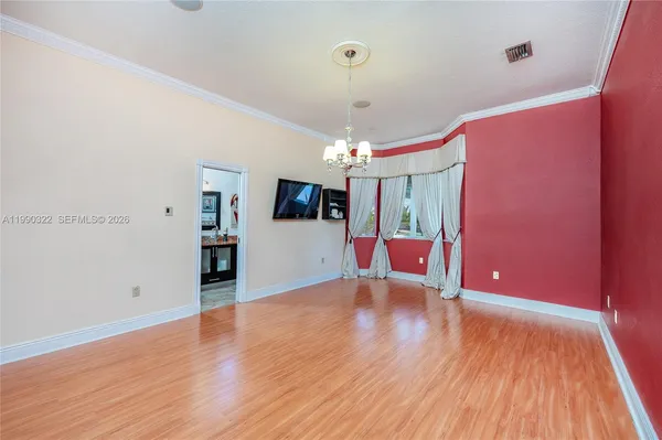 en view of an empty room with window and chandelier fan