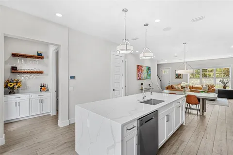 a kitchen with a sink stove and wooden floor