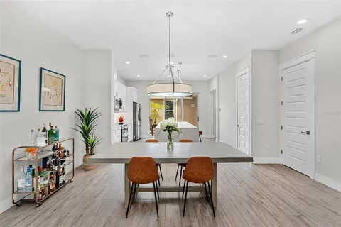 a dining room with furniture potted plants and wooden floor